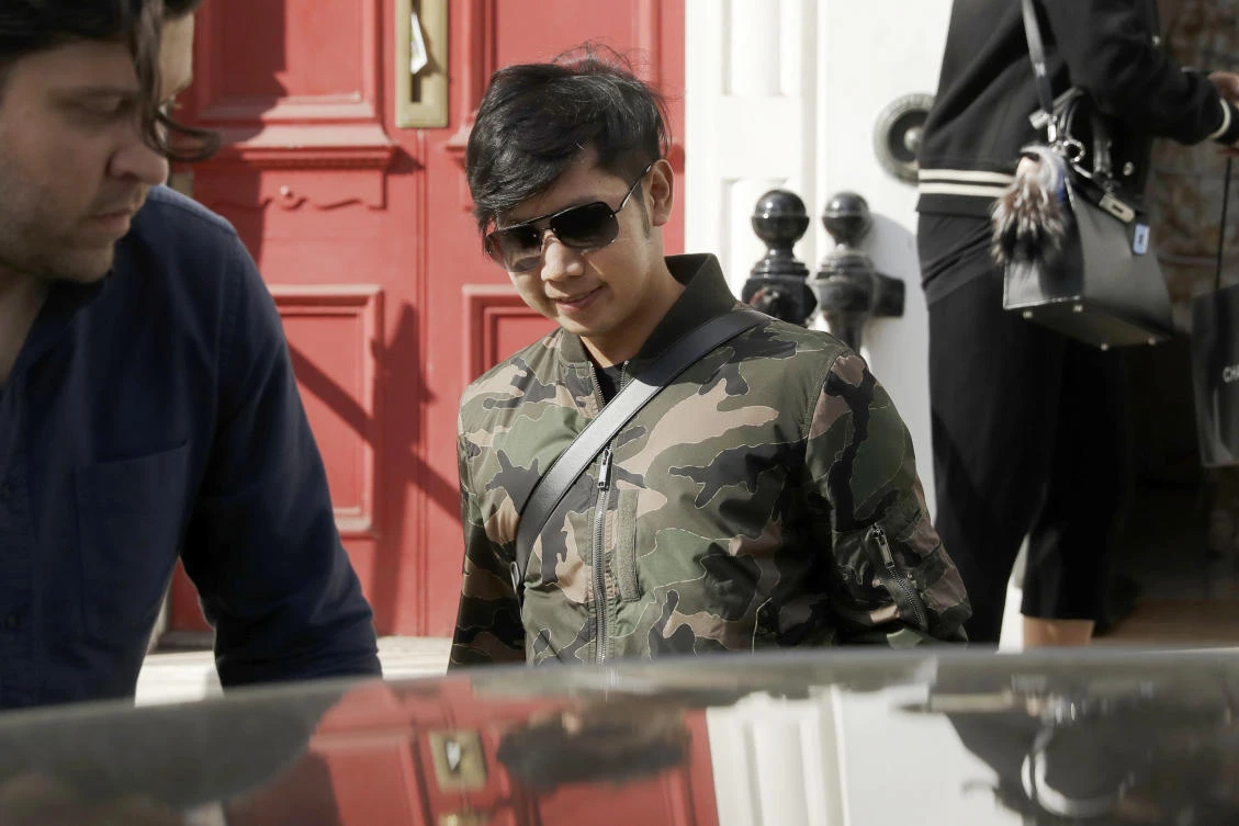 In this April 5, 2017, photo, Vorayuth "Boss" Yoovidhya, whose grandfather co-founded energy drink company Red Bull, walks to get in a car as he leaves a house in London. Interpol on Monday, Aug. 28, 2017, issued an international request for the arrest of the billionaire heir to the Red Bull energy drink fortune, stepping up the hunt for the fugitive Thai playboy wanted in allegedly killing of a traffic policeman in a 2012 hit-and-run incident in Bangkok. (AP)