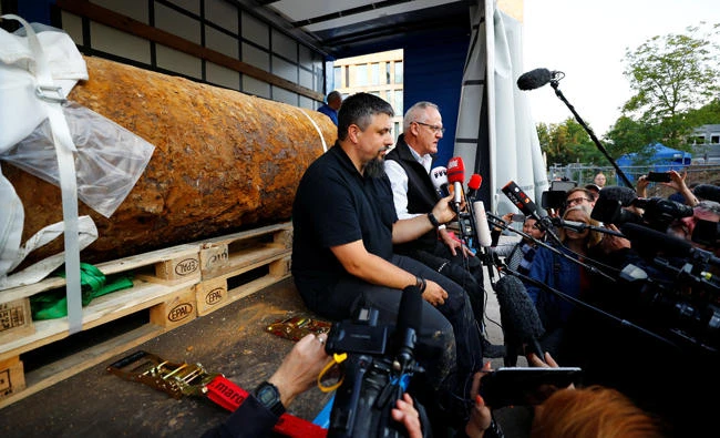 Bomb disposal experts Rene Bennert and Dieter Schweizler speak to journalits next to a defused massive World War II bomb after tens of thousands of people evacuated their homes in Frankfurt, Germany, on September 3, 2017. (REUTERS/Kai Pfaffenbach)