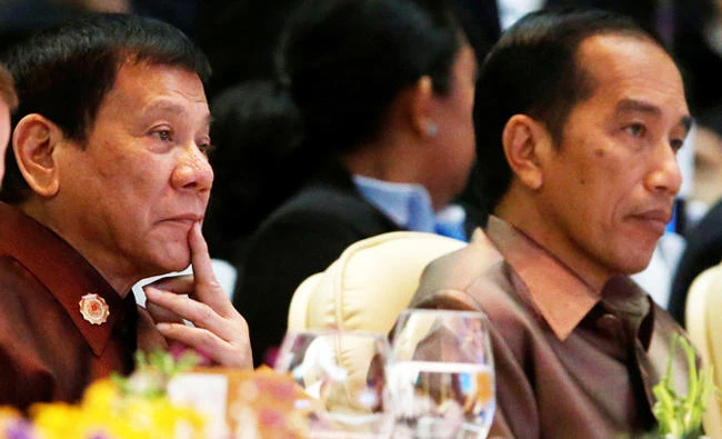 Philippine President Rodrigo Duterte (L) and Indonesia's President Joko Widodo are seen at the ASEAN Summit gala dinner in Vientiane, Laos, in this September 7, 2016 photo. The two leaders are to meet soon to discuss the Daesh threat in Southeast Asia. (REUTERS/Jonathan Ernst)