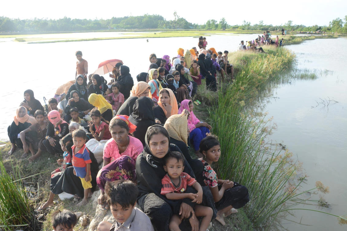 Fleeing Rohingya refugees pause to rest at the Bangladesh-Myanmar border. (AN photo)