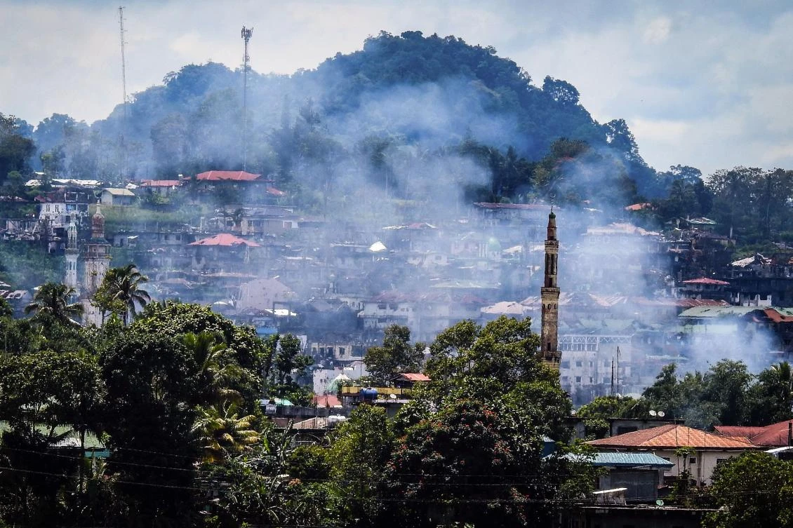 Smoke rises from houses as battles continue in Marawi on the southern island of Mindanao on August 28, 2017. Soldiers killed 10 suspected militants on August 28 as they attempted to infiltrate by boat, a Philippine city that has been under siege by pro-Islamic State gunmen for over three months, officials said. (AFP)