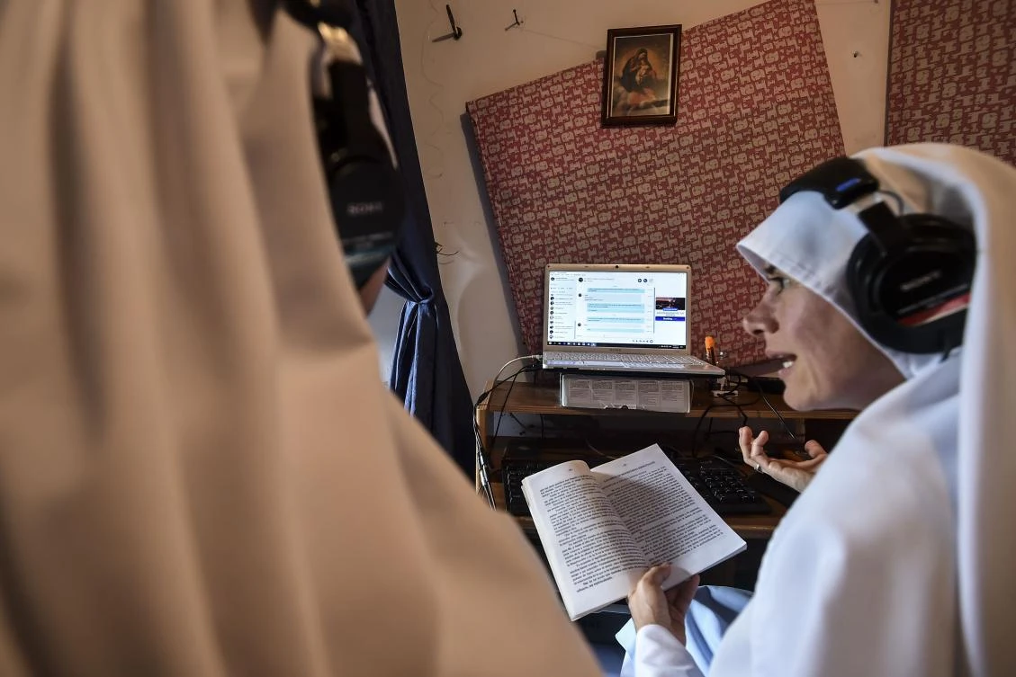 Rafaela, a fellow nun of Maria Valentina de los Angeles, of the “Comunicadoras Eucaristicas del Padre Celestial” (Eucharistic Communicators of the Celestial Father) congregation, makes an internet radio program at a convent in the outskirts of Cali, Colombia, on July 17, 2017. Nun Maria Valentina de los Angeles –who wears tennis shoes, raps and already participated in a reality show- will see her dream of singing to Pope Francis come true during his visit to Colombia. - TO GO WITH AFP STORY BY RODRIGO ALMONACID / AFP / Luis ROBAYO / TO GO WITH AFP STORY BY RODRIGO ALMONACID