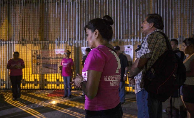 Activists pray at the wall between Mexico and US during a protest against the possibility of deportation of dreamers included in DACA program in Playas de Tijuana, Baja California, Mexico on September 4, 2017. (AFP / GUILLERMO ARIAS)