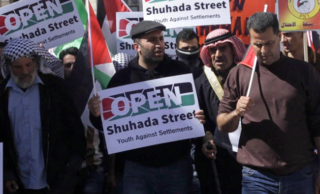 In this Feb. 26, 2016 file photo, Palestinian activist Issa Amro, center, participates in a demonstration in the West Bank city of Hebron. (AP Photo/Mahmoud Illean, File)