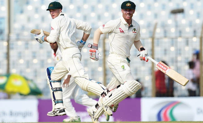 Australian cricketers David Warner, right, and Peter Handscomb run between the wickets during the second day of the second cricket Test match between Bangladesh and Australia at Zahur Ahmed Chowdhury Stadium in Chittagong on Tuesday. (AFP)