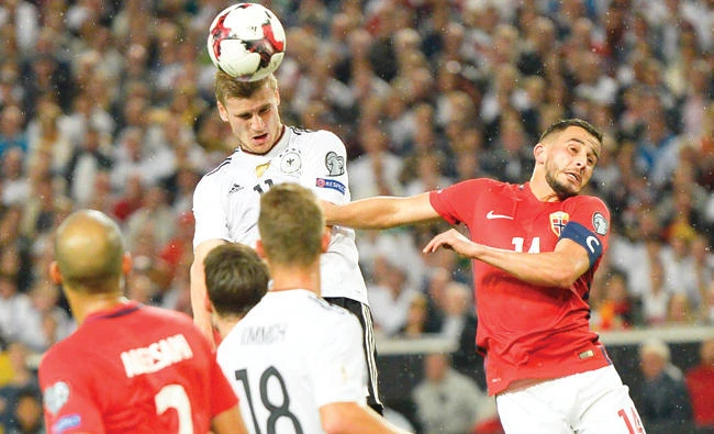 Germany’s forward Timo Werner, center, rises above the Norwegian defense to head in his side’s fourth goal during the FIFA World Cup 2018 qualification match between Germany and Norway in the south German city of Stuttgart on Monday. (AFP)