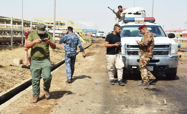 Iraqi security forces and members of the Saraya al-Salam (Peace Brigades), a group formed by Iraqi Shiite cleric Moqtada al-Sadr, inspect the site of suicide bombings at a power plant north of the capital Baghdad, in this September 2, 2017 photo. (AFP)