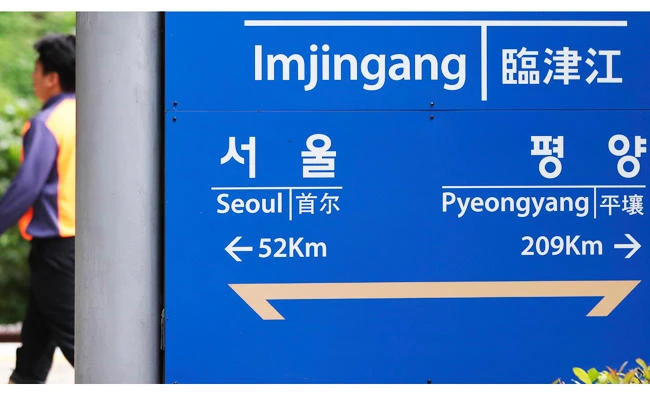 A man walks near a signboard showing the distance to the North Korea's capital Pyongyang and to South Korea's capital Seoul from Imjingang Station in Paju, South Korea, on Tuesday. (AP)