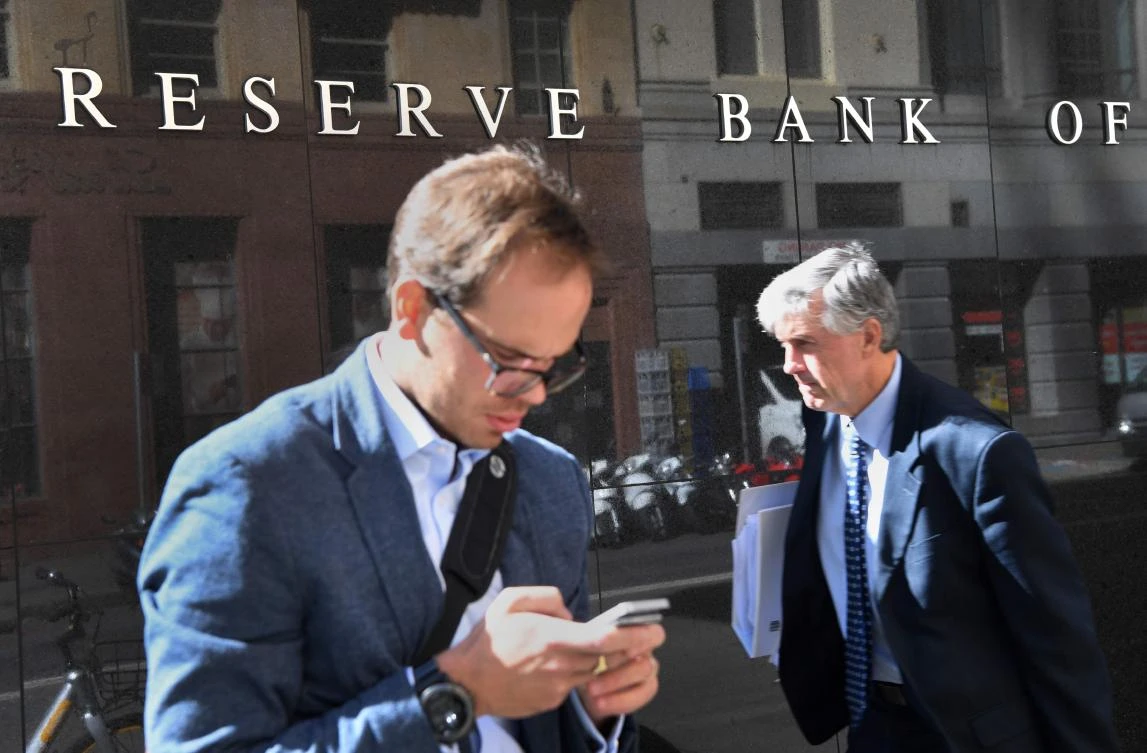 Men walk past the Reserve Bank of Australia sign in Sydney. (AFP)