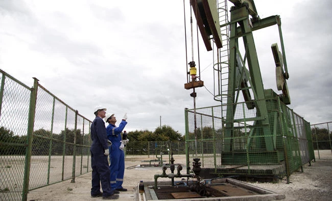 Thierry Oger, right, a production manager for Canadian based Vermilion oil company, and Jean-Pascal Simart, head of public affairs, watch an oil rig, on Wednesday, Sept. 6, 2017 in Andrezel, southeast of Paris. France's government has unveiled a law to ban all production and exploration of oil and natural gas by 2040 on the country's mainland and overseas territories. (AP Photo/Thibault Camus)