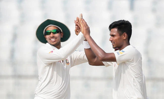 Bangladesh's Mustafizur Rahman, right, celebrates with his teammate Soumya Sarkar after the dismissal of Australia's David Warner during the third day of their second Test cricket match in Chittagong, Bangladesh, Wednesday. (AP)