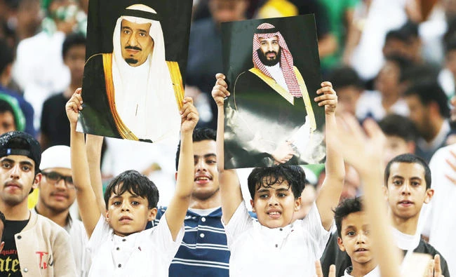 Saudi fans hold up portraits of King Salman and Crown Prince Mohammed bin Salman during the FIFA World Cup 2018 qualification football match between Saudi Arabia and Japan at King Abdullah Stadium in Jeddah on Tuesday. (AFP)