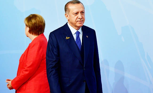 This file photo taken on July 7, 2017 shows German Chancellor Angela Merkel (L) standing next to Turkey's President Recep Tayyip Erdogan as he arrives to attend the G20 summit in Hamburg, northern Germany. (AFP)