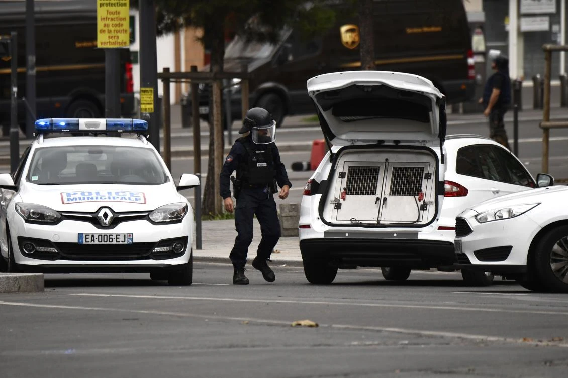 A police officer walks towards a police vehicle carrying a police dog (R), in Villejuif, a suburb of Paris, on September 6, 2017 as two men were arrested after the discovery of explosives and bomb components at an apartment. (AFP)