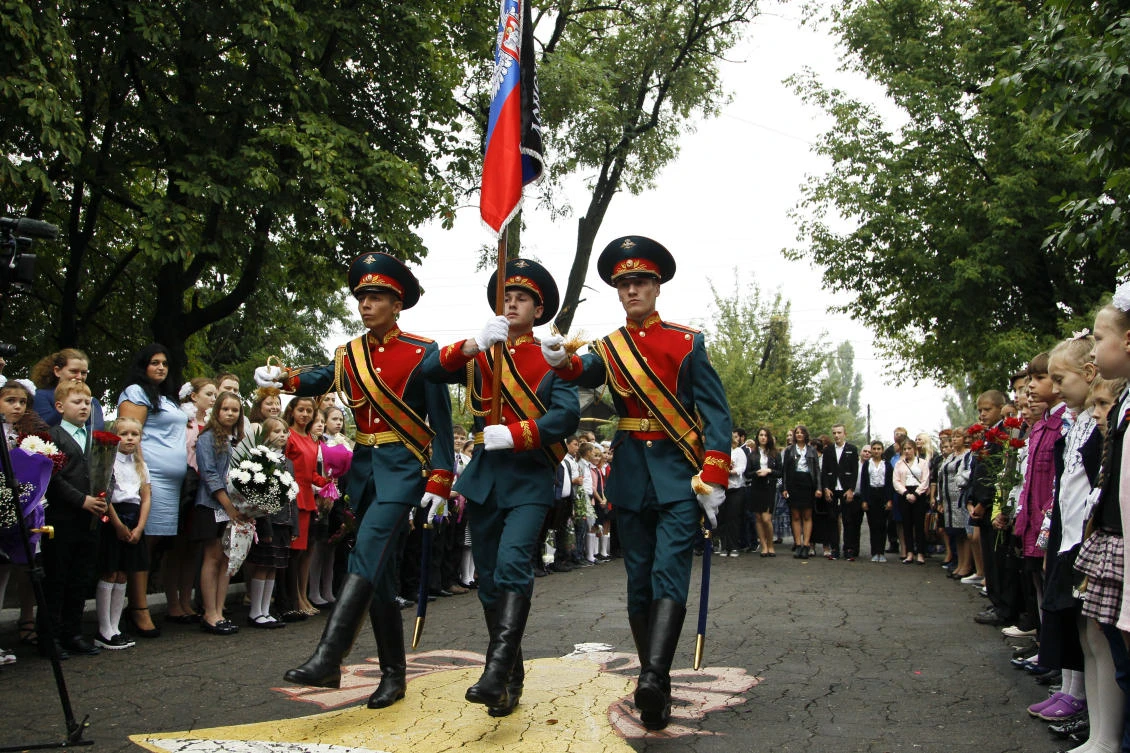 Schoolchildren watch as servicemen carry a flag of the Russia-backed self-proclaimed separatist Donetsk republic, at a ceremony on the first day of school in Donetsk, Ukraine. (AP)