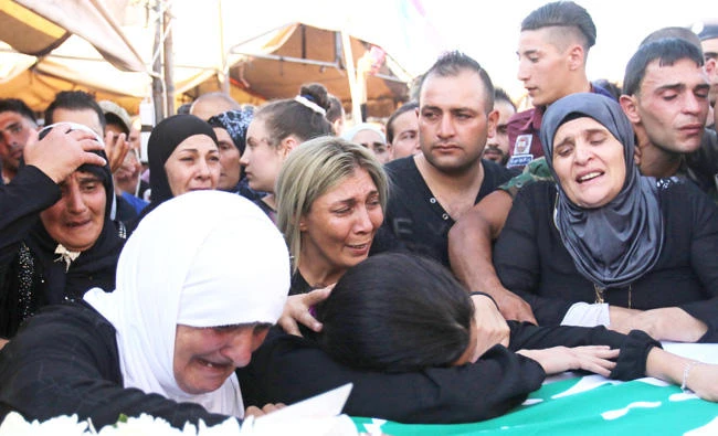 Relatives mourn over the coffin of Mohammed Youssef, one of the 10 Lebanese soldiers who died after they had been taken hostage in 2014 by Daesh and whose remains were found along the Syrian border, during his funeral in the town of Mdoukha in Lebanon’s eastern Bekaa valley on Friday. (AFP)