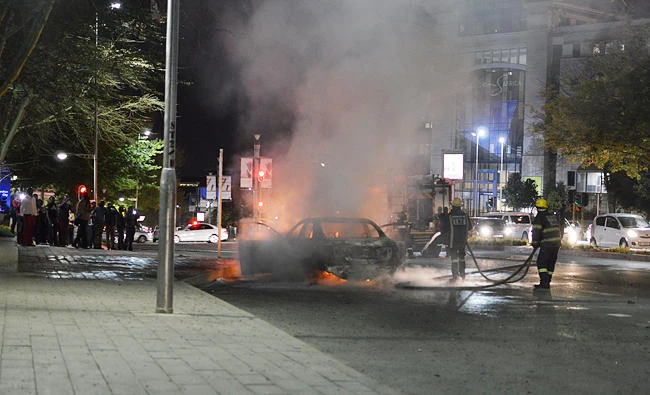 Firefighters extinguish a car that police said was set on fire during a confrontation between Uber and meter taxi drivers in Sandton, South Africa, on Thursday. (REUTERS)