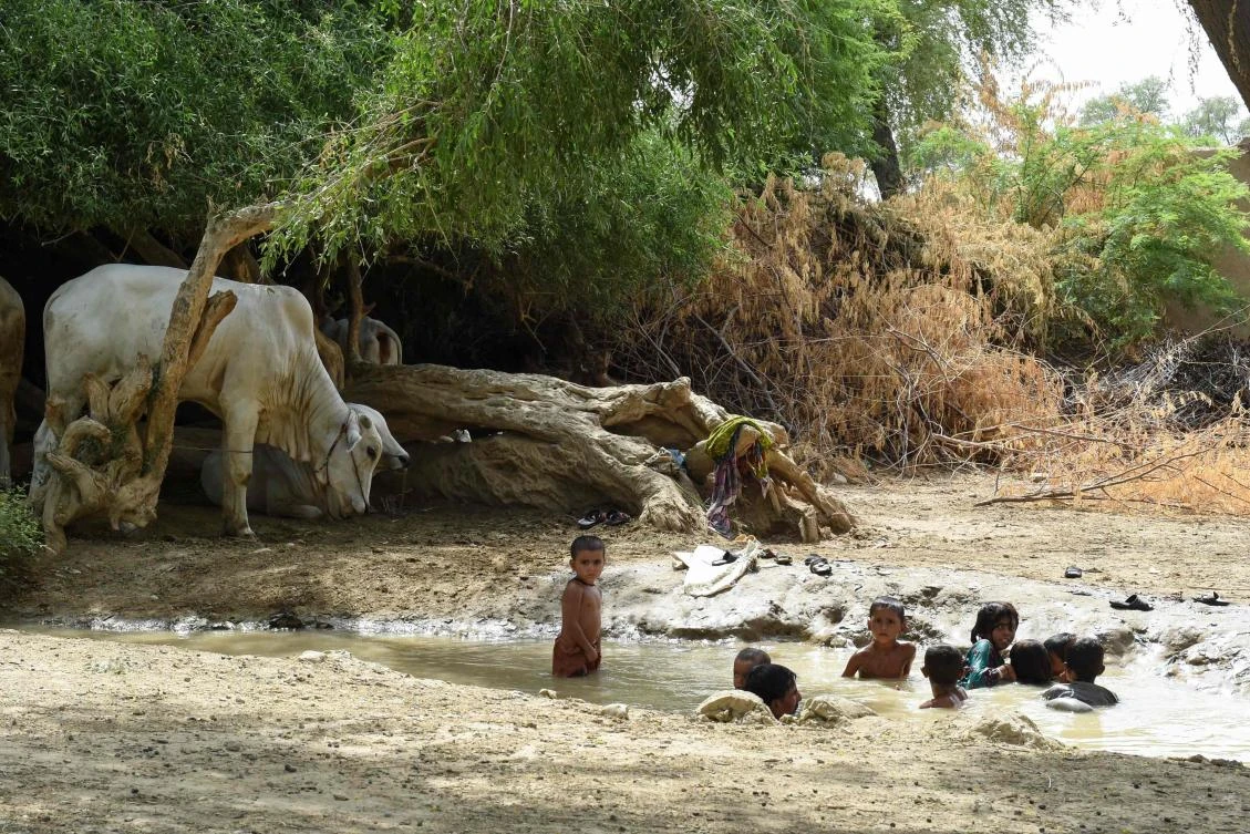 In this photograph taken on August 11, 2017, Pakistani children cool themselves off in a stream during a hot day in Sibi, in Pakistan's southwestern Balochistan province. Scientists have warned that swathes of South Asia may be uninhabitable due to rising temperatures by 2100 -- and in the desert community of Sibi in southwest Balochistan province, where the mercury hit 52.4 degrees Celsius (126 Fahrenheit) this summer, it feels like they could be right. (AFP)