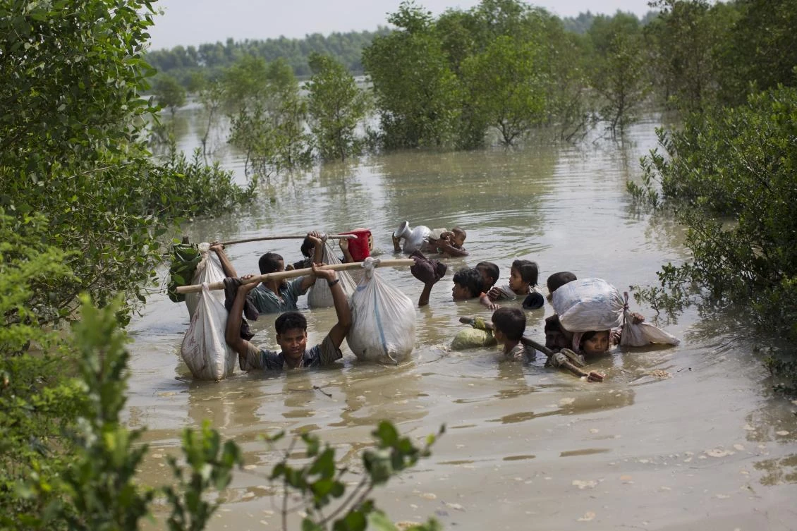 A Rohingya family reaches the Bangladesh border after crossing a creek of the Naf river on the border with Myanmmar, in Cox's Bazar's Teknaf area, Tuesday, Sept. 5, 2017. (AP)