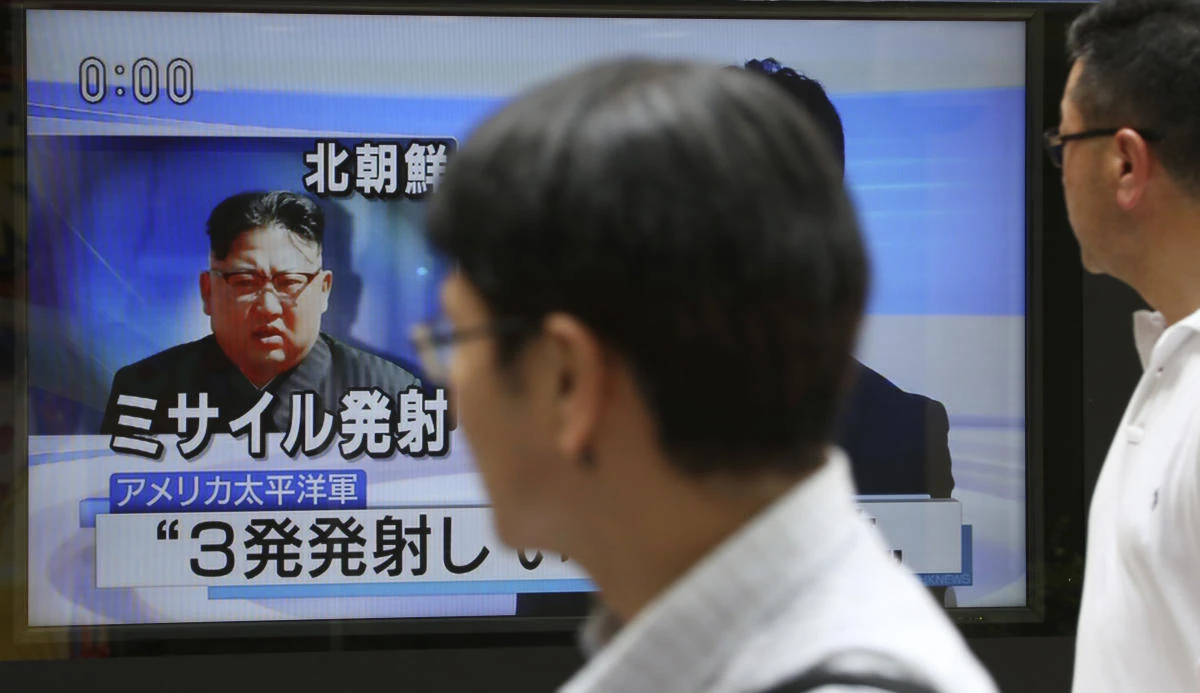 Passers-by watch a TV news program showing image of North Korean leader Kim Jong Un, in Tokyo, Saturday, Aug. 26, 2017. Three North Korea short-range ballistic missiles failed on Saturday, U.S. military officials said, which, if true, would be a temporary setback to Pyongyang's rapid nuclear and missile expansion. Japanese letters read: "North Korea fired three missiles." (AP)