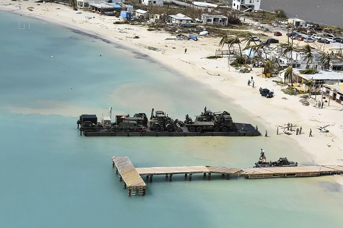 In a handout picture released by the British Ministry of Defence on September 8, 2017 a British Army Royal Logistics Corps Mexeflote landing raft is used to land vehicles and a generator on Sandy Bay Village beach during a disaster relief operation in Anguilla in the Eastern Caribbean on September 7, 2017. The Royal Navy landing ship RFA Mounts Bay has delivered six tonnes of emergency aid to Anguilla, the British Overseas Territory devastated by Hurricane Irma, and will shortly arrive in the British Virgin Islands to provide further support, the MOD said on September 8. Hurricane Irma ripped through the Caribbean leaving a trail of devastation and killing 17 as it barrelled towards the United States where up to a million people have been told to flee. (AFP PHOTO / MOD / CROWN COPYRIGHT 2017)