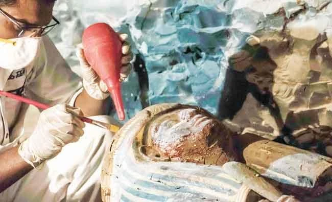 An Egyptian archaeologist restoring a wooden sacrophagus at a newly-uncovered ancient tomb in Luxor. (AFP)
