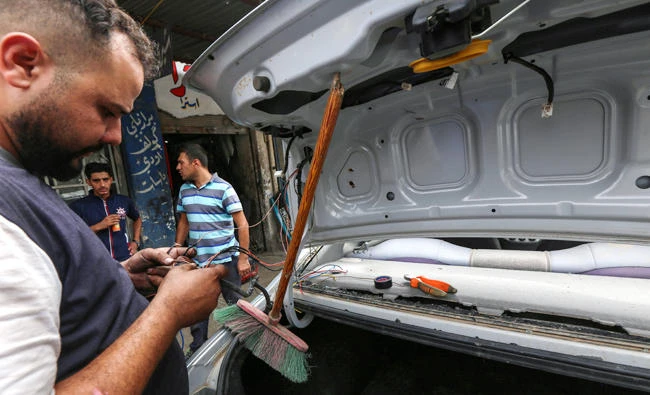 Iraqi mechanics work in a garage in east Mosul as they repair vehicles that were damaged during the offensive to retake Iraq’s second-largest city from Daesh terrorists. (AFP)