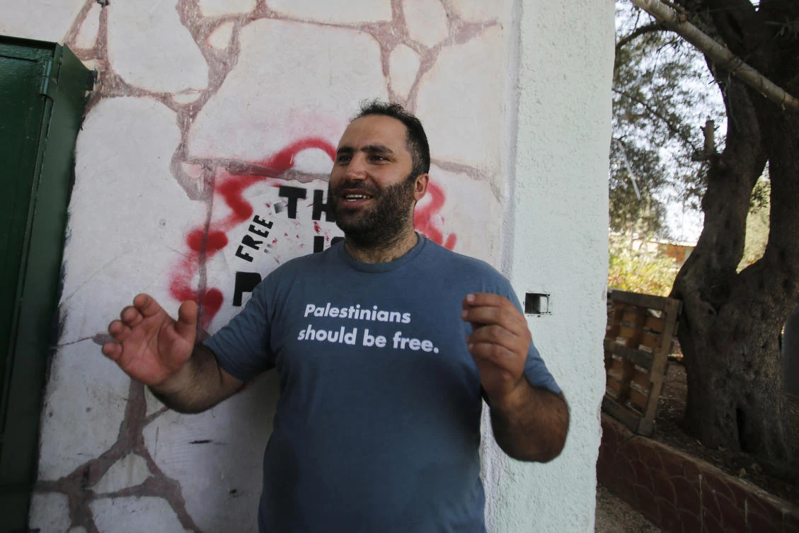 Palestinian activist Issa Amro, center, speaks after his release from detention, in the West Bank city of Hebron, Sunday, Sept. 10, 2017. The Palestinian Authority has released Amro a week after he was arrested for writing a Facebook post criticizing the government of President Mahmoud Abbas. (AP Photo/Nasser Shiyoukhi)