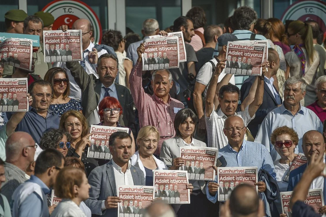 Protesters hold Cumhuriyet daily newspapers during a demonstration before the controversial trial of staff from Turkey's main opposition daily on September 11, 2017 at the Silivri district in Istanbul. The case, which opened in Istanbul in July, involves 17 current and former writers, cartoonists and executives from Cumhuriyet ("Republic") who are being tried on "terror" charges in a move denounced by supporters as absurd. (AFP)