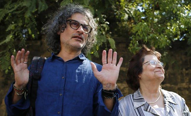Lebanese film director Ziad Doueiri, left, stands next to his mother, Wafiqa, as he speaks to journalists after being released by a military court, in Beirut, Lebanon, on Monday, Sept. 11, 2017. (AP Photo/Hassan Ammar)