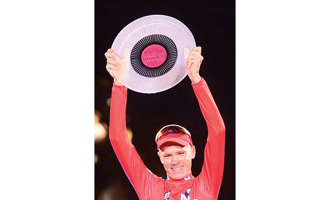 Team Sky’s British cyclist Chris Froome raises his trophy as he celebrates on the podium winning the La Vuelta Tour of Spain cycling race in Madrid on Sunday.(AFP)