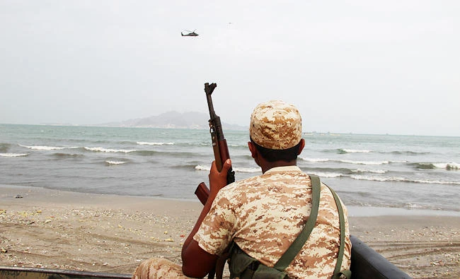 A Yemeni soldier looks as a UAE military helicopter hover over the sea during the search for the wreckage of a crashed UAE military helicopter off the southern city of Aden, Yemen, in this file photo. (Reuters)