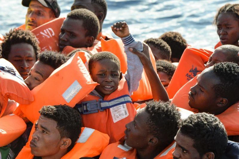 A young boy is seen among the migrants and refugees seated on a rubber boat and waiting to be rescued by the Topaz Responder, a rescue ship run by Maltese NGO “Moas” and the Italian Red Cross, off the Libyan coast (AFP)