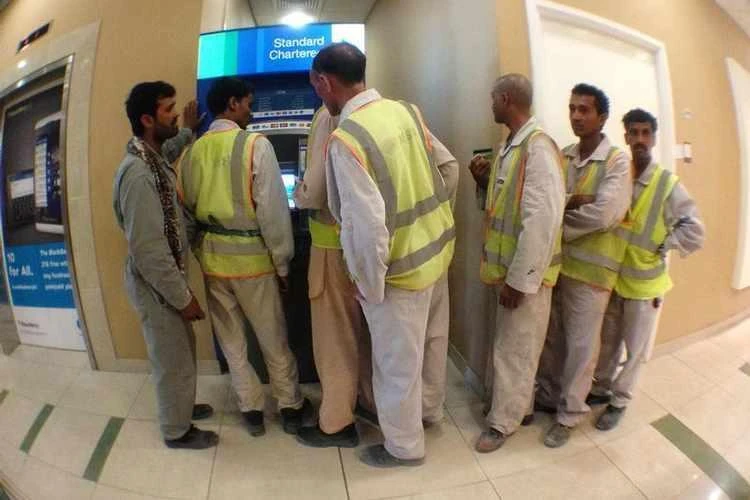 Indian workers queue at an ATM machine in Dubai Media City. (REUTERS)