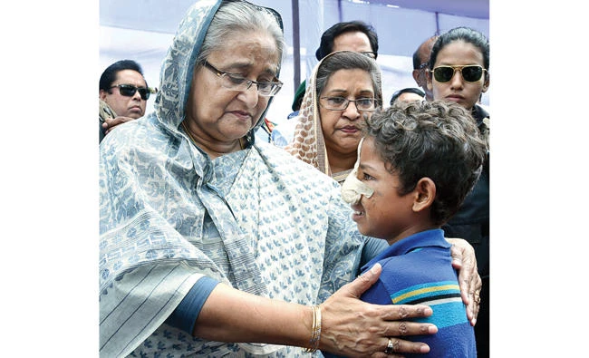 Bangladeshi Prime Minister Sheikh Hasina, center, meets with a Rohingya Muslim child at Kutupalong refugee camp, near the border town of Ukhia, Bangladesh, Tuesday. (AP)