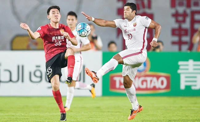 Guangzhou Evergrande’s Li Xuepeng, left, competes for the ball with Shanghai SIPG’s Hulk during their AFC Champions League quarterfinal football match in Guangzhou in China’s southern Guangdong province on Tuesday. (AFP)