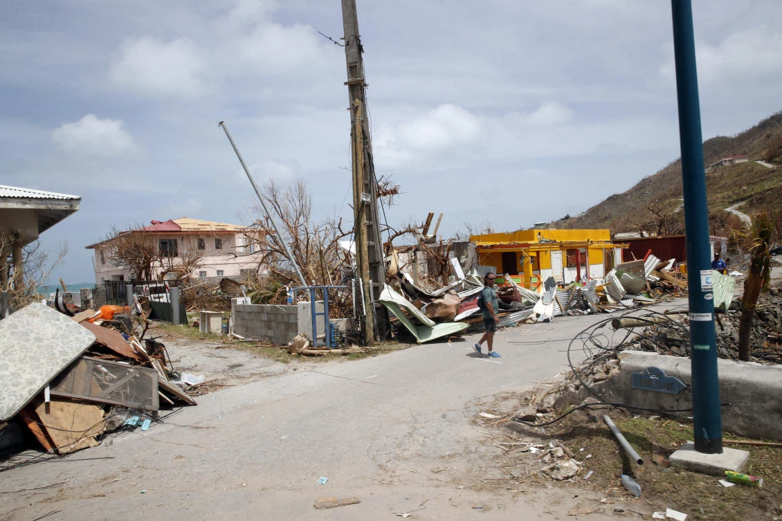 A man walks next to damaged house destroyed by Irma during the visit of France's President Emmanuel Macron in the French Caribbean islands of St. Martin. (AP)