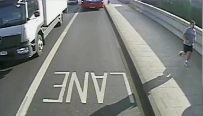 A man jogging whom police wish to speak to after a a woman was pushed into the path of a bus on Putney Bridge. (Photo courtesy: video grab)