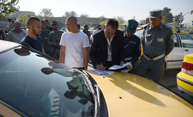 An Afghan refugee, center, deported from Germany is registered by an International Organization for Migration (IOM) member after arriving in Kabul on Wednesday. (AFP)