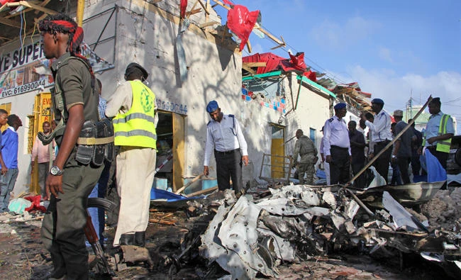Somali soldiers examine the wreckage following a car bomb blast in Mogadishu, Somalia on Sept. 11, 2017, by al-Shabaab extremists. On Wednesday, six fighters of the Al-Qaeda linked terror group were killed in air strikes by US forces in Somalia. (AP Photo/Farah Abdi Warsameh)