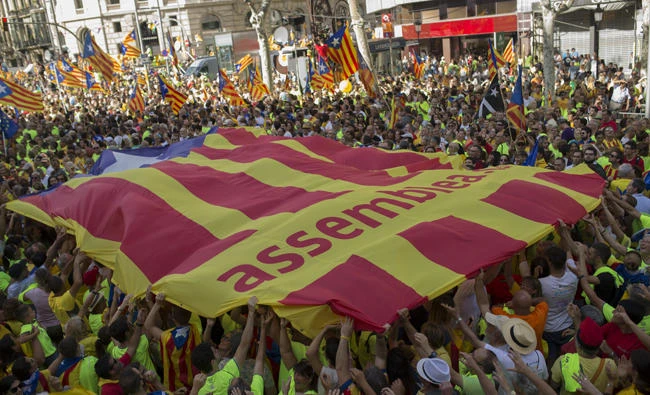 People holds up a giant estelada or independence flag during the Catalan National Day in Barcelona, Spain, Monday Sept. 11, 2017. Hundreds of thousands rally in Barcelona to show support for an independent Catalan nation and the right to vote in a controversial referendum that has been banned by Spain. (AP Photo/Francisco Seco)