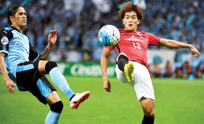 Urawa Reds forward Toshiyuki Takagi, right, fights for the ball with Kawasaki Frontale defender Elsinho during the AFC Champions League quarterfinal match between Urawa Reds and Kawasaki Frontale in Saitama, Japan, on Wednesday. (AFP)