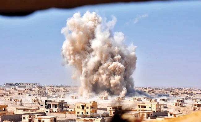 Smoke rises from buildings in the area of Bughayliyah, on the northern outskirts of Deir Ezzor, on Wednesday, as Syrian regime forces advance during the battle against Daesh. (AFP)