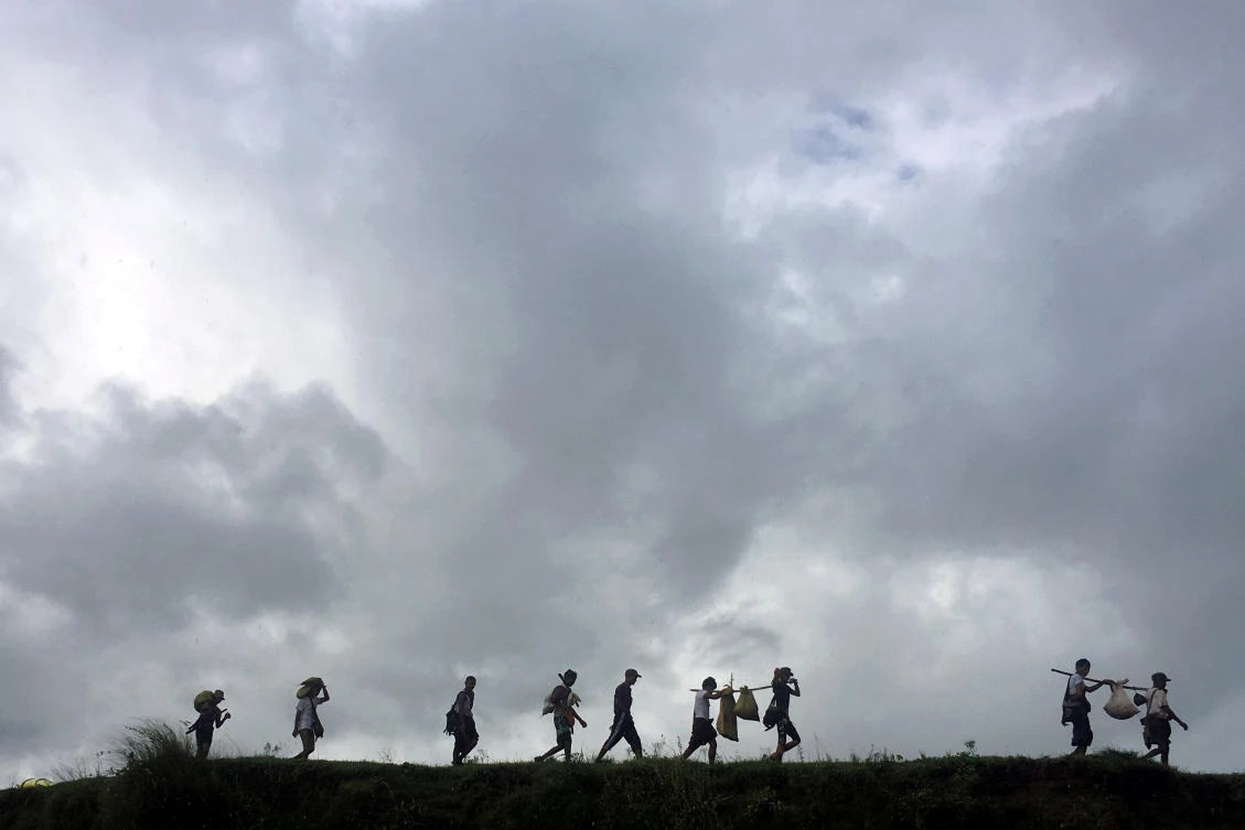 People displaced by violence walk in the banks of Mayu river with their belongings while moving to another village, in Buthidaung in the north of Rakhine state, Myanmar
