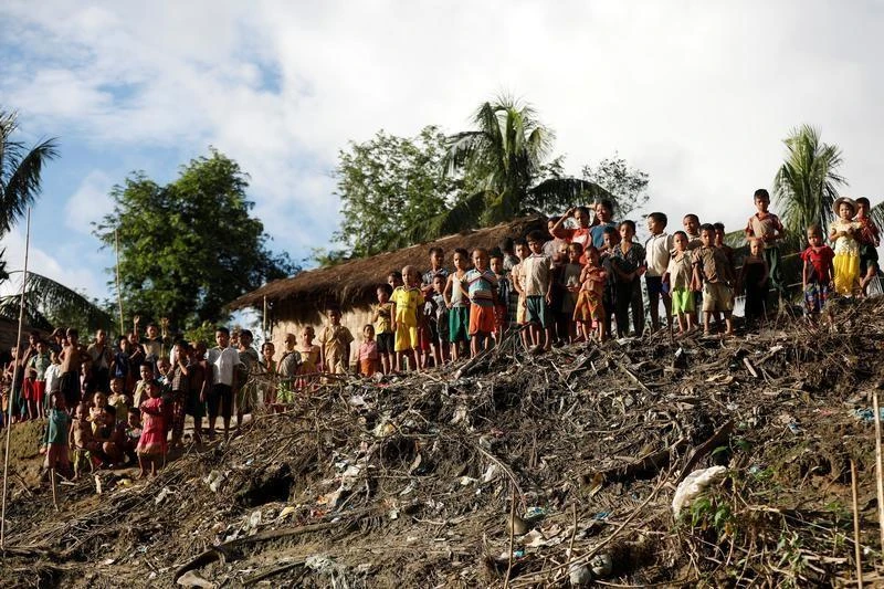 Children from an Mro community look at boats delivering rice bags from a local NGO near Buthidaung in the north of Rakhine state, Myanmar September 13, 2017. (REUTERS)