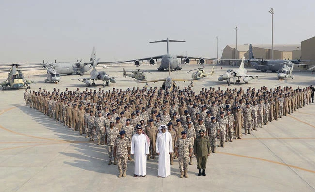 In this Sept. 11, 2017 photo released by Qatar News Agency, the Qatari Emir Sheikh Tamim bin Hamad Al Thani, center front, poses for a photo with Emiri Air Force at al-Udeid Air Base in Doha, Qatar. (QNA via AP)