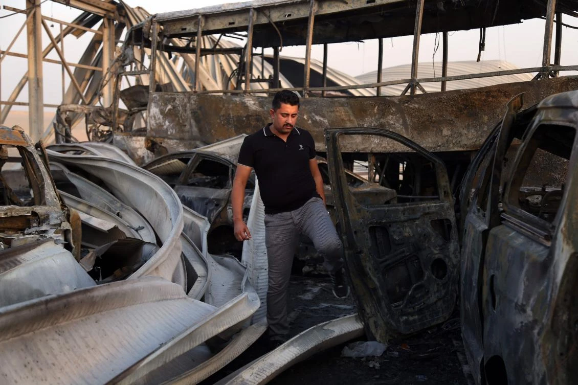 An Iraqi man looks at the damage after gunmen and suicide car bombers killed dozens of people in two assaults claimed by Daesh group jihadists near the southern Iraqi city of Nasiriyah. (AFP)