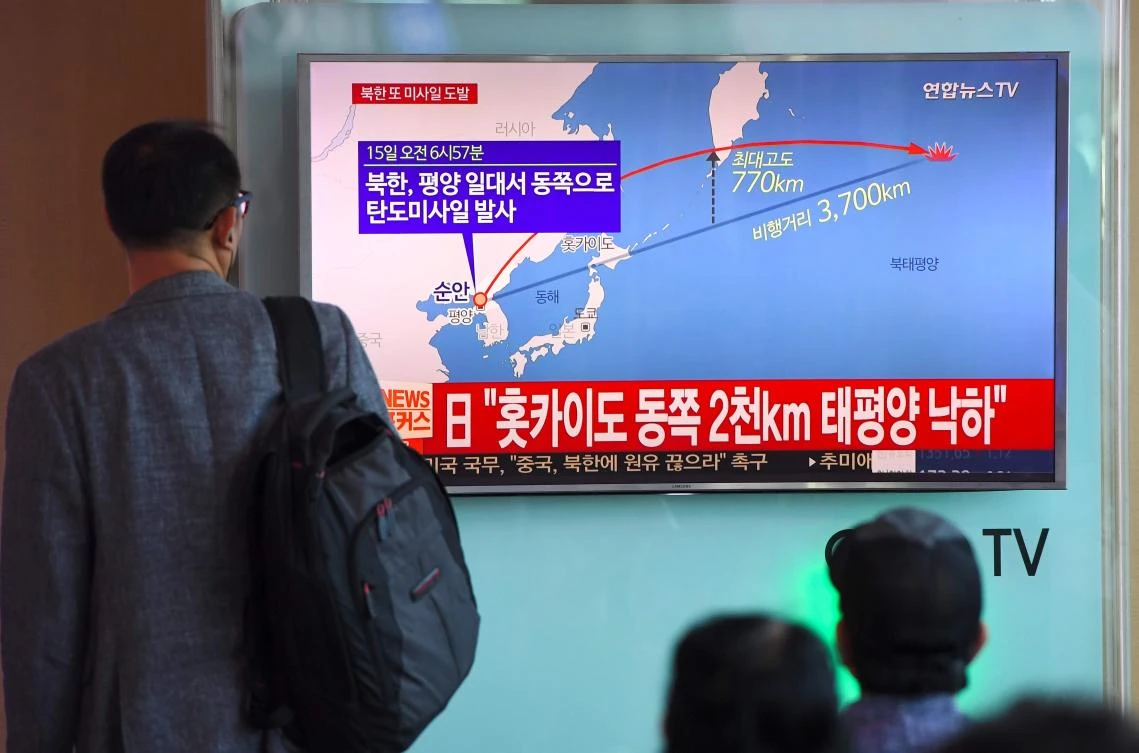A man watches a screen showing a graphic of the North Korean missile launch at a railway station in Seoul. (AFP)