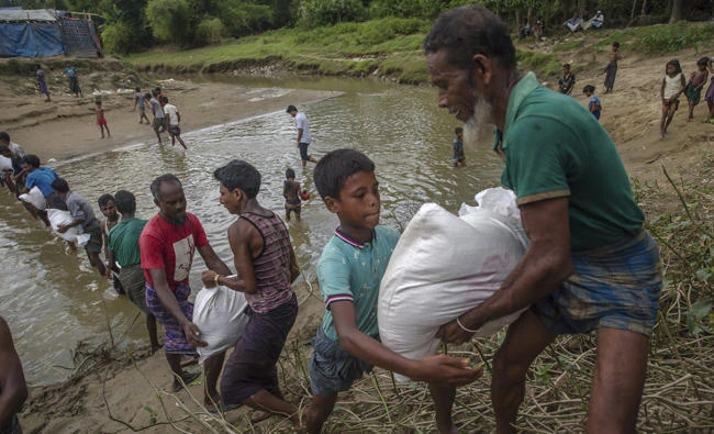 Fleeing Rohingya Muslims watch as homes burn in Myanmar