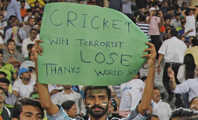 A Pakistani cricket fan holds a placard during a final of Twenty20 International match between World XI and Pakistan at Gaddafi stadium in Lahore, Pakistan, on Friday, Sept. 15, 2017. The series is aimed at reviving international cricket in Pakistan, since terrorists attacked the Sri Lanka cricket team bus in Lahore in 2009. (AP Photo/K.M. Chaudary)